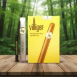ซิการ์ Villiger Premium No.1 Sumatra กล่องสีเหลือง วางคู่กับมวนซิการ์ในห่อฟอยล์และบุหรี่ขนาดปกติเพื่อเทียบขนาด