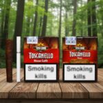 กล่องซิก้าร์ Toscanello สูตร Rosso Caffè และ Rosso Macchiato วางบนโต๊ะไม้ในสวนป่า